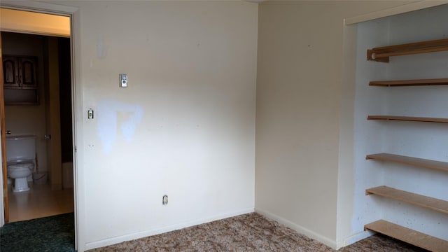 spare room featuring baseboards and carpet