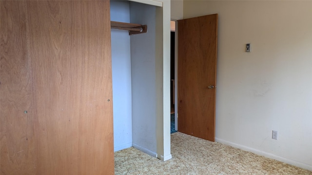 unfurnished bedroom featuring a closet, baseboards, and carpet flooring