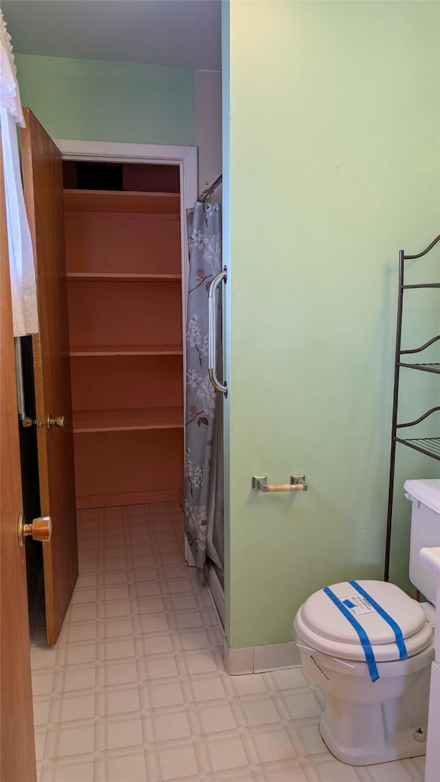 full bathroom with curtained shower, tile patterned floors, and toilet