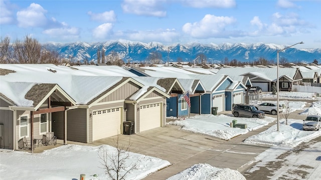 view of front of home featuring driveway, a mountain view, a residential view, board and batten siding, and a garage