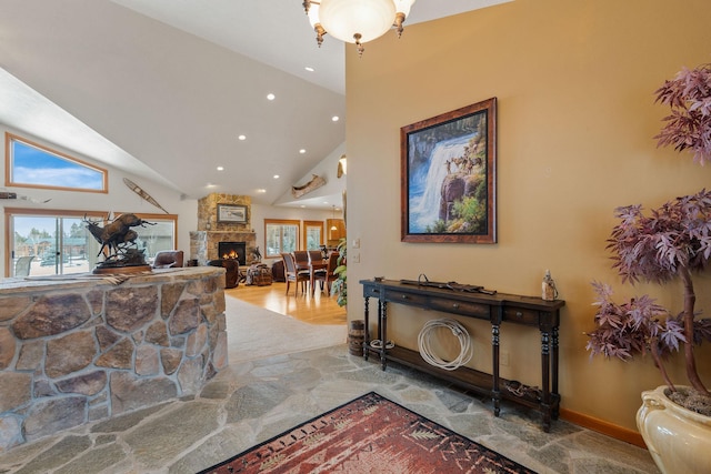 interior space featuring recessed lighting, stone finish floor, high vaulted ceiling, and baseboards