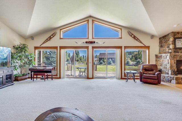 living room with a stone fireplace, high vaulted ceiling, and carpet floors