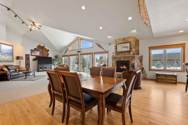 dining area featuring light wood-style floors, a healthy amount of sunlight, and a fireplace