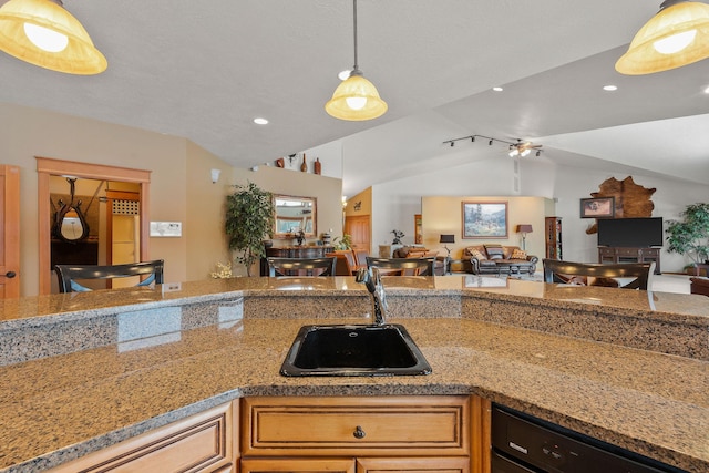 kitchen with vaulted ceiling, open floor plan, dishwasher, and a sink