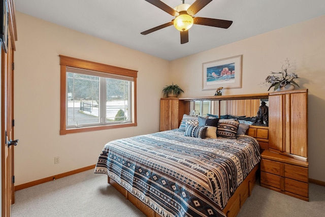 carpeted bedroom with ceiling fan and baseboards