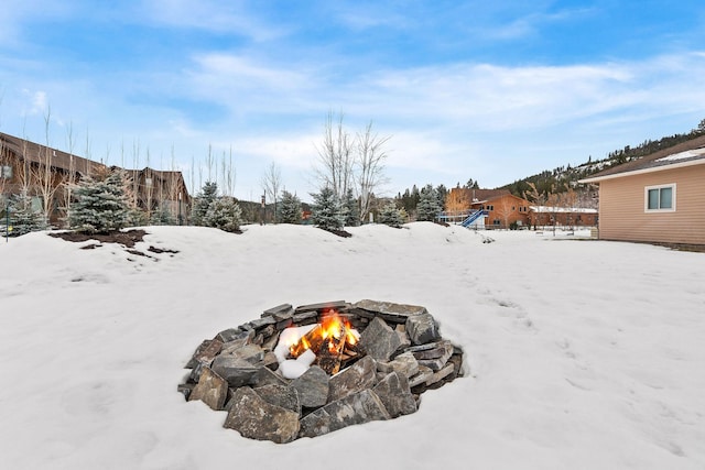 yard layered in snow featuring a fire pit