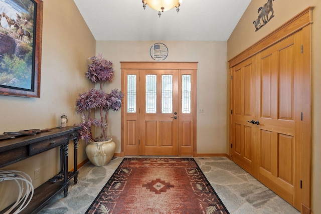 carpeted foyer entrance featuring baseboards