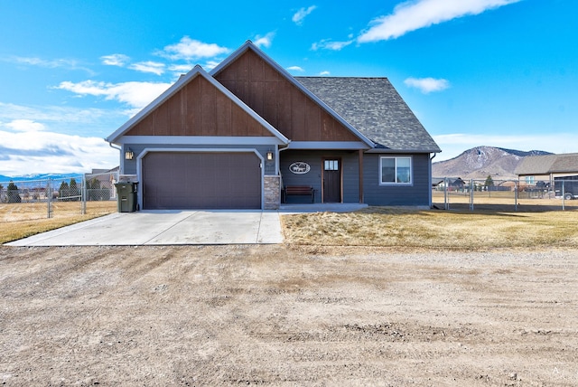 view of front of home featuring an attached garage, fence, a front yard, driveway, and a mountain view