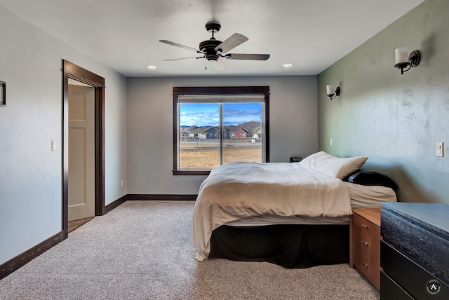 bedroom with light colored carpet, baseboards, and ceiling fan