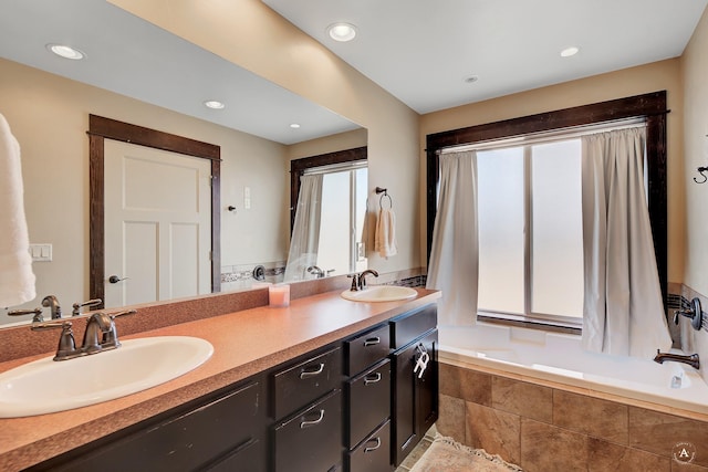 full bathroom with a sink, recessed lighting, double vanity, and tiled bath