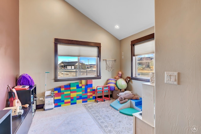 rec room with carpet floors and vaulted ceiling