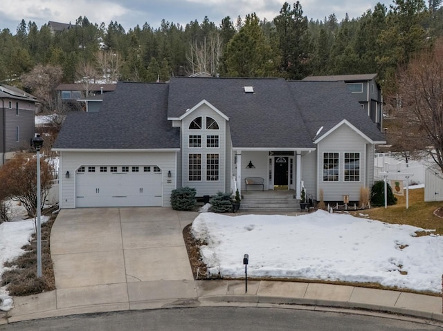 traditional-style house featuring a porch, concrete driveway, a garage, and a shingled roof