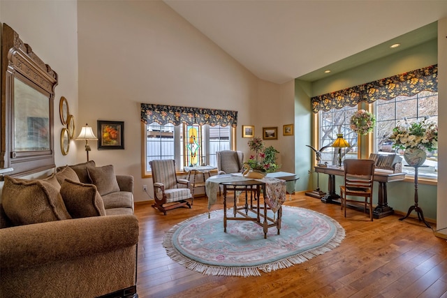 living room with recessed lighting, baseboards, high vaulted ceiling, and hardwood / wood-style floors