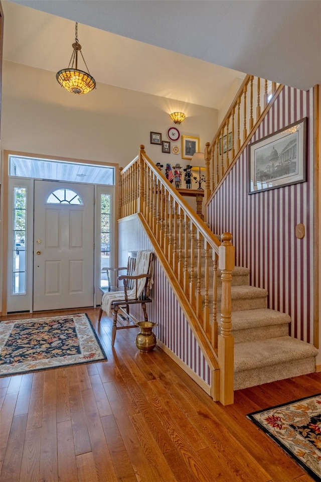 entrance foyer featuring a wealth of natural light, stairs, and hardwood / wood-style floors