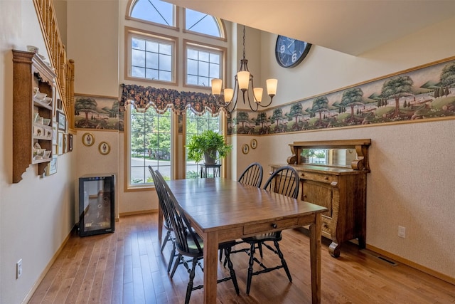 845 S California St, Helena, MT 59601 - dining room featuring light wood-style flooring, a chandelier, a high ceiling, and wine cooler
