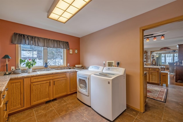 washroom featuring washing machine and clothes dryer, visible vents, laundry area, tile patterned floors, and a sink