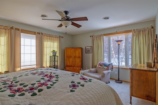 bedroom with multiple windows, visible vents, and light carpet