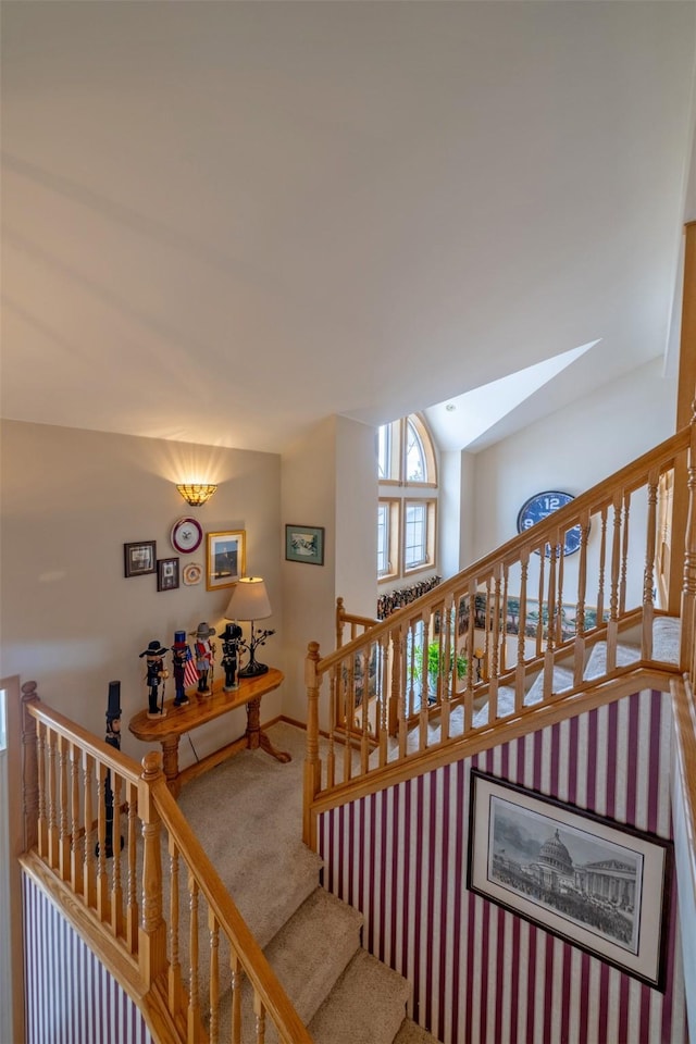 stairs with lofted ceiling with skylight and carpet