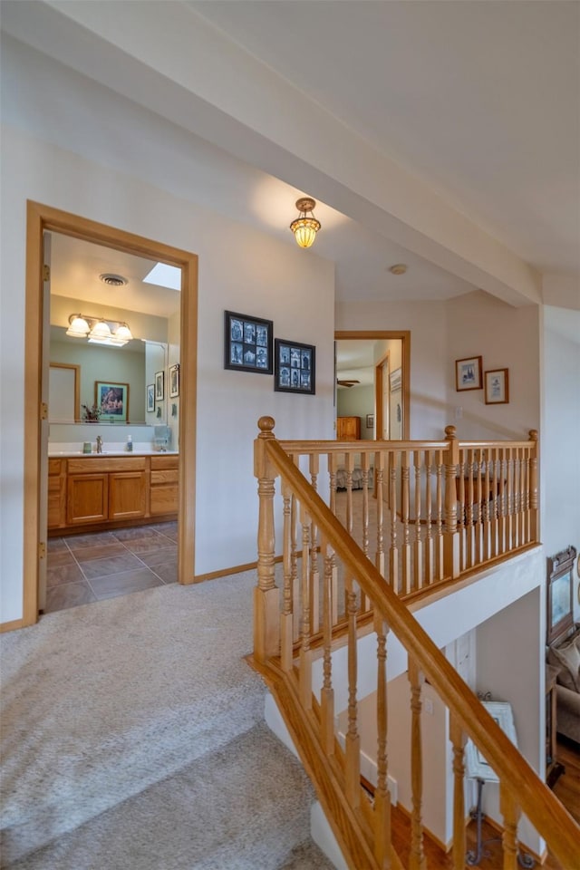 stairway with baseboards, carpet floors, and visible vents