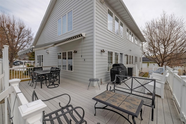 wooden terrace featuring outdoor dining space and area for grilling