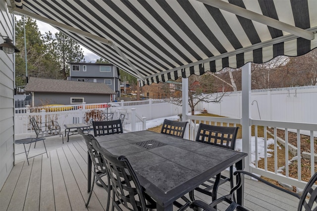 wooden deck with a fenced backyard and outdoor dining space