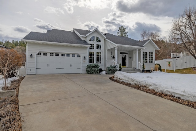 view of front of property featuring driveway, an attached garage, roof with shingles, and fence