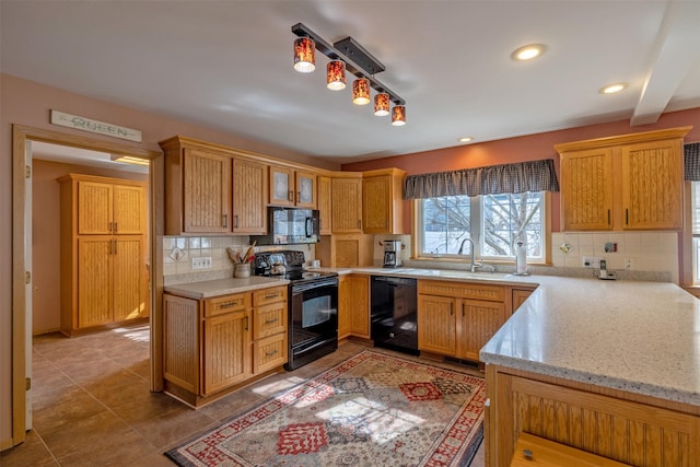 kitchen with tasteful backsplash, light stone countertops, recessed lighting, black appliances, and a sink