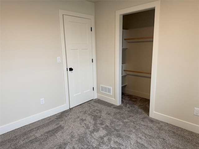 unfurnished bedroom with baseboards, visible vents, carpet floors, a spacious closet, and a closet