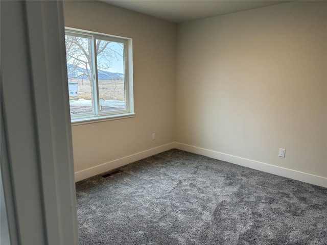 carpeted empty room featuring visible vents, baseboards, and a wealth of natural light