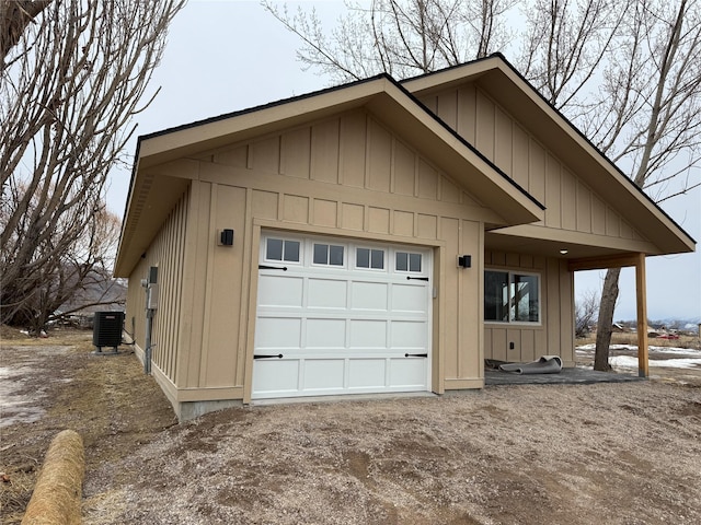 garage with central AC unit and dirt driveway