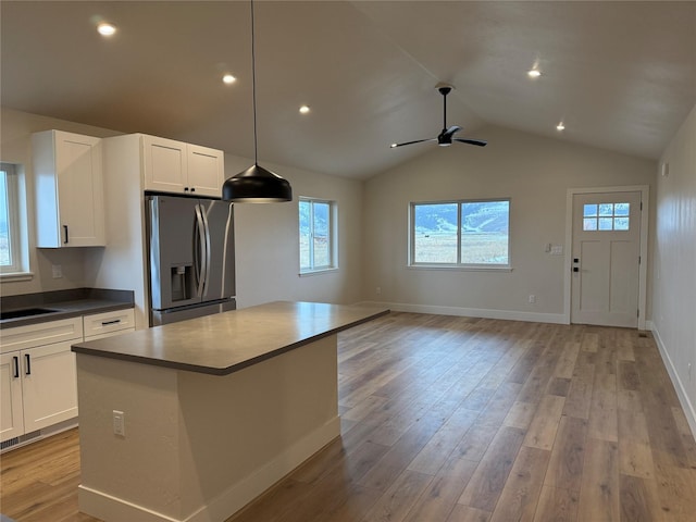 kitchen featuring dark countertops, white cabinets, stainless steel refrigerator with ice dispenser, and light wood finished floors