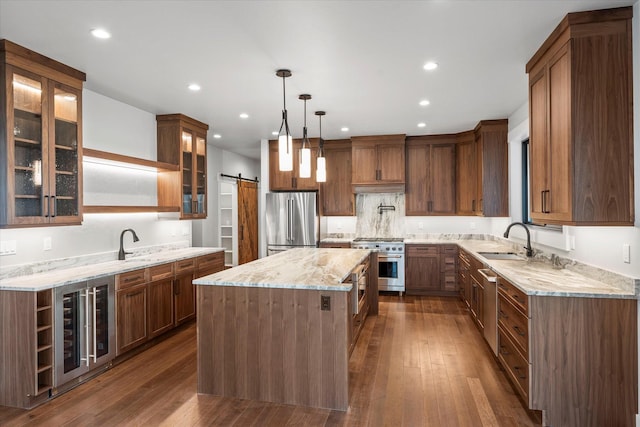 kitchen featuring beverage cooler, a sink, premium appliances, a kitchen island, and a barn door