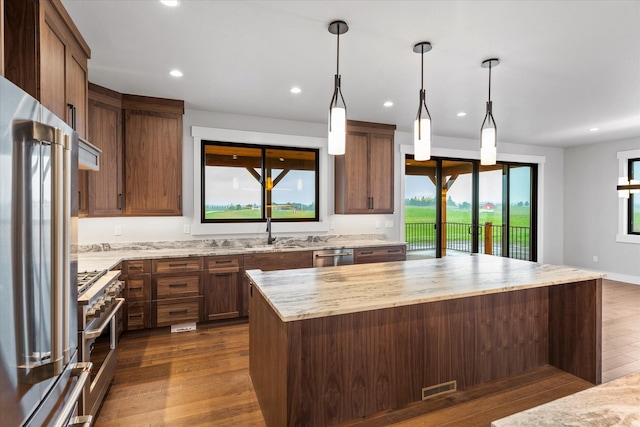 kitchen with dark wood-style floors, recessed lighting, a center island, and high quality appliances