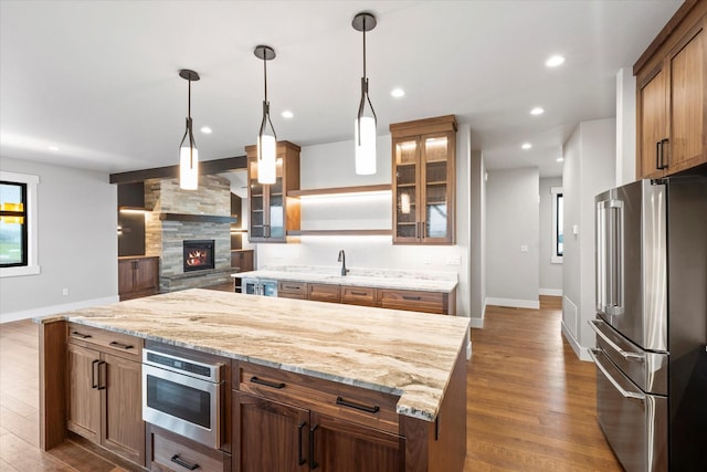 kitchen featuring dark wood-style floors, recessed lighting, freestanding refrigerator, glass insert cabinets, and a center island