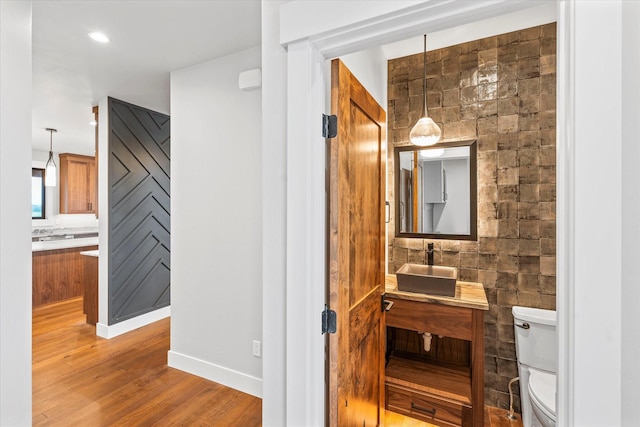 bathroom with recessed lighting, toilet, wood finished floors, and vanity