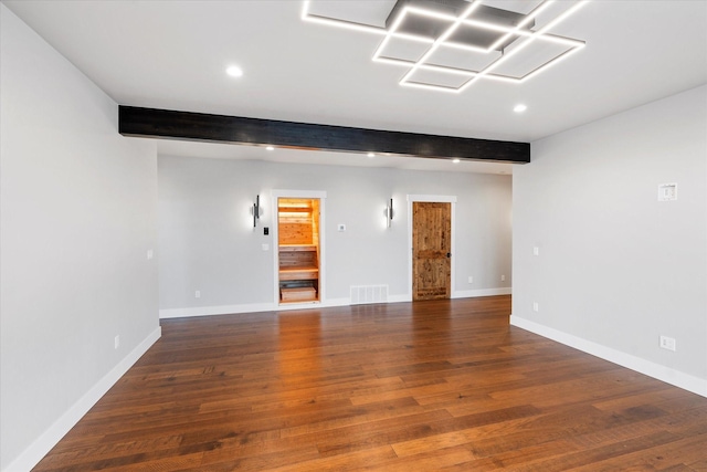 unfurnished room featuring visible vents, beam ceiling, and wood finished floors