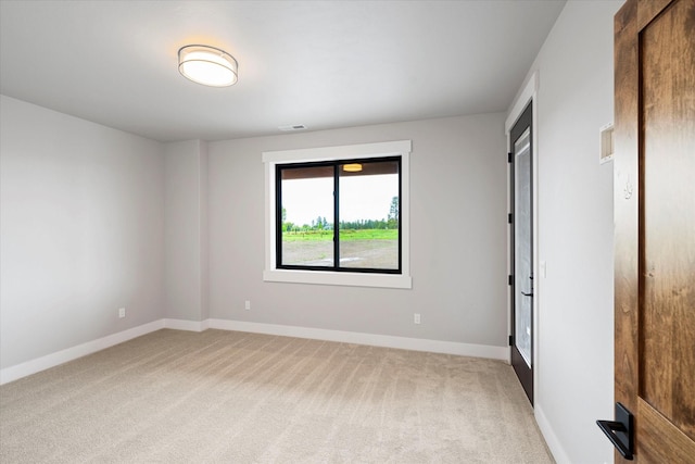 empty room with visible vents, light colored carpet, and baseboards