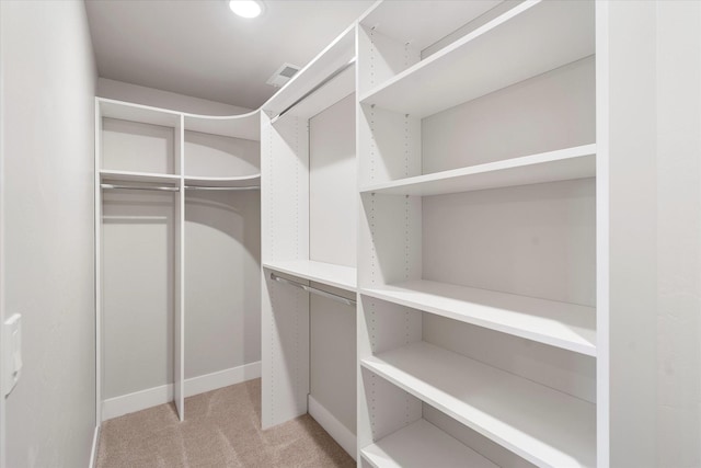 walk in closet with visible vents and light colored carpet