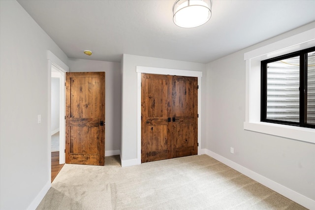 unfurnished bedroom with a closet, baseboards, and carpet floors