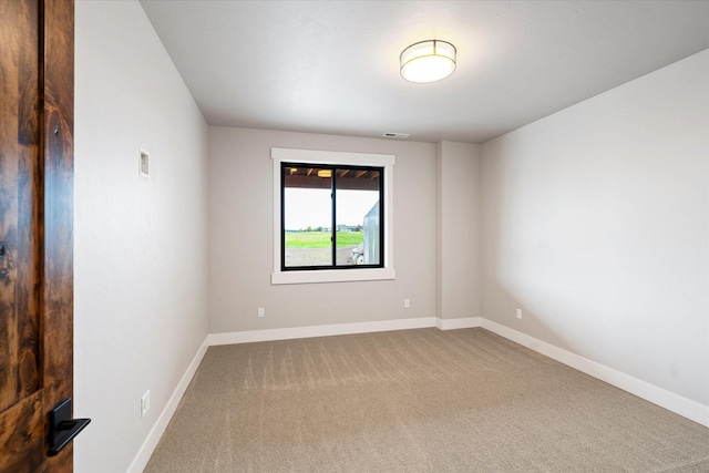 carpeted empty room with visible vents and baseboards