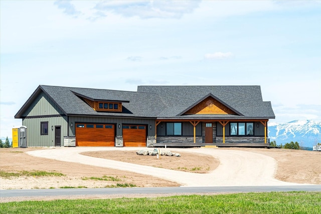 view of front of home featuring a mountain view, roof with shingles, board and batten siding, and dirt driveway