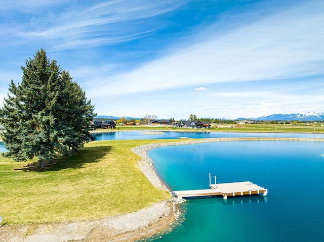 dock area with a lawn and a water view