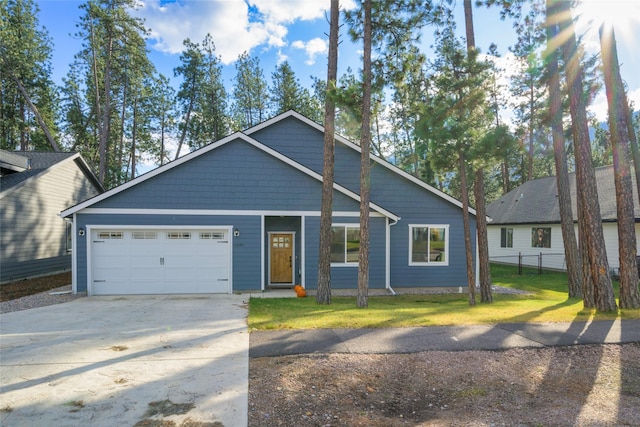 view of front of house featuring concrete driveway, fence, a garage, and a front yard