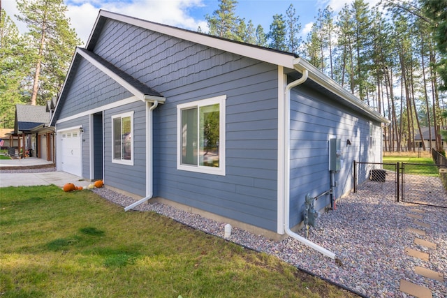 view of property exterior with fence, a lawn, driveway, an attached garage, and a gate