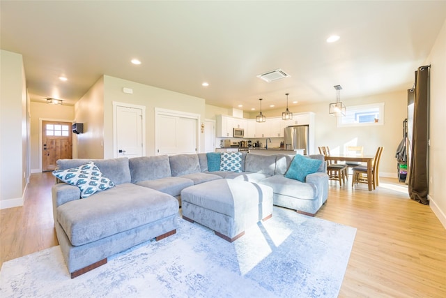 living area featuring light wood finished floors, visible vents, recessed lighting, and baseboards