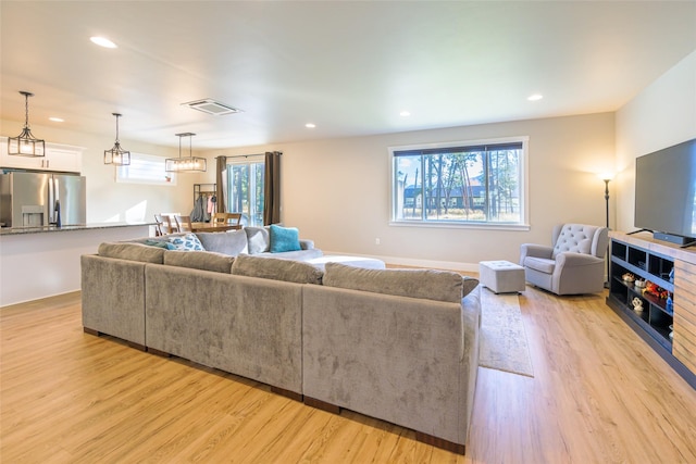 living area with visible vents, recessed lighting, and light wood-style floors