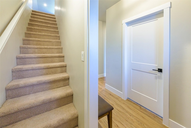 stairway with baseboards and wood finished floors