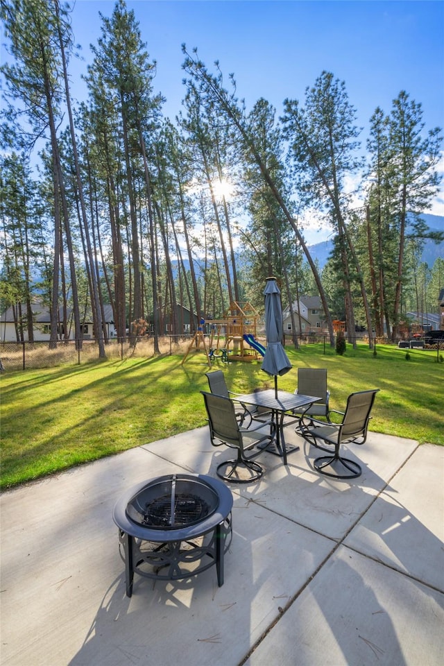 view of patio / terrace with an outdoor fire pit and a playground