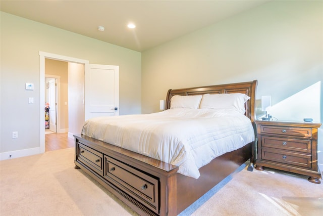 bedroom with light carpet, recessed lighting, and baseboards