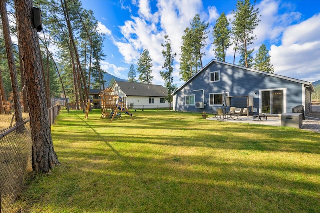 back of house with a yard, a patio, a fenced backyard, and a playground